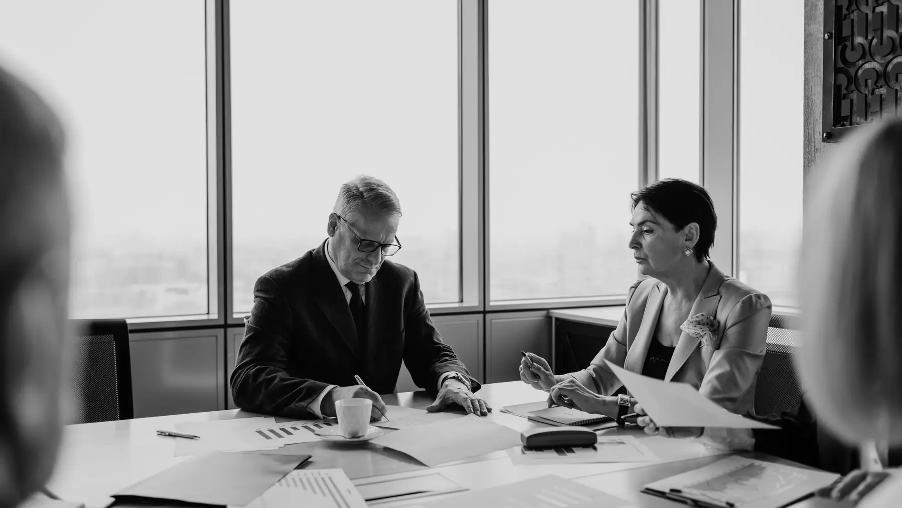 Reunión de trabajo junto a un ventanal, en blanco y negro
