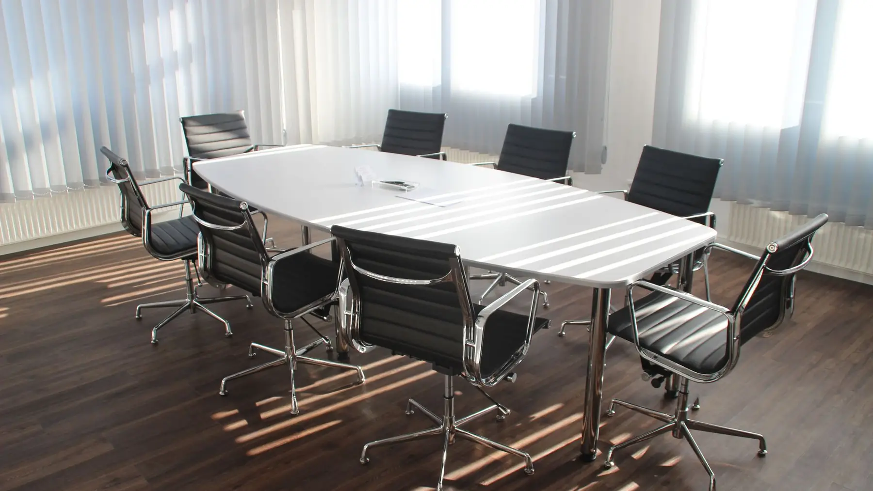 Sala de reuniones vacía con ventanales y luz natural