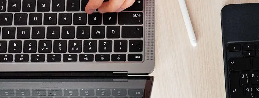 Manos sobre el teclado de un notebook en un escritorio claro